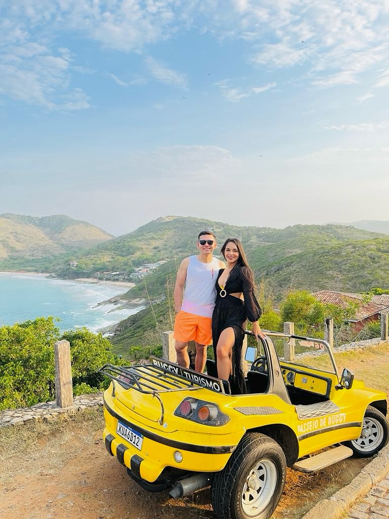 Casal em buggy amarelo com vista para Búzios
